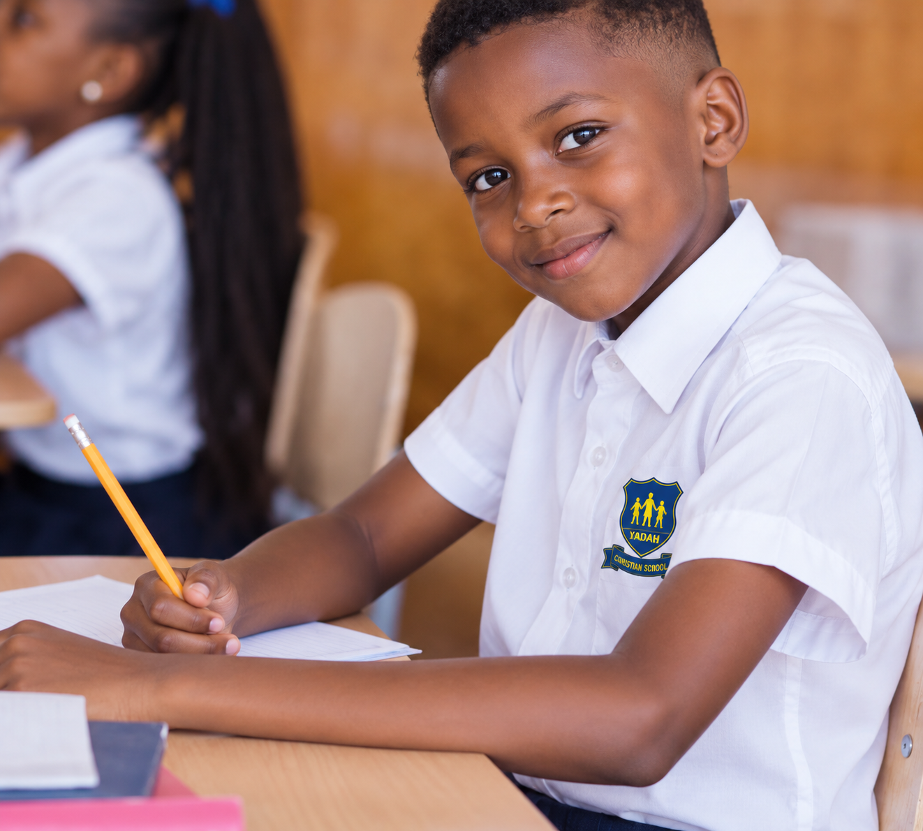 A smiling Yadah learner at his desk